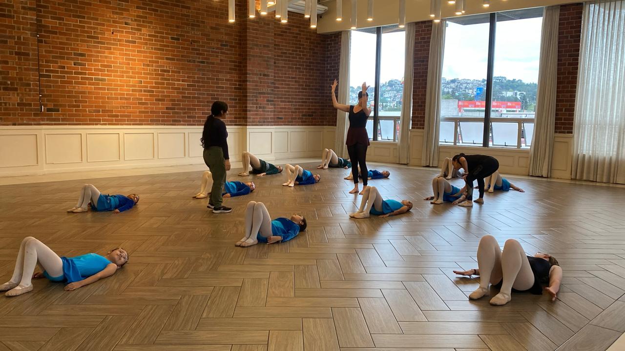Clase en el estudio de Eddanza: alumnas estirando en el piso con sus maestras